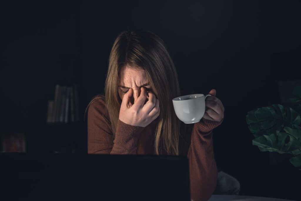 Jovem com sono tomando café a noite