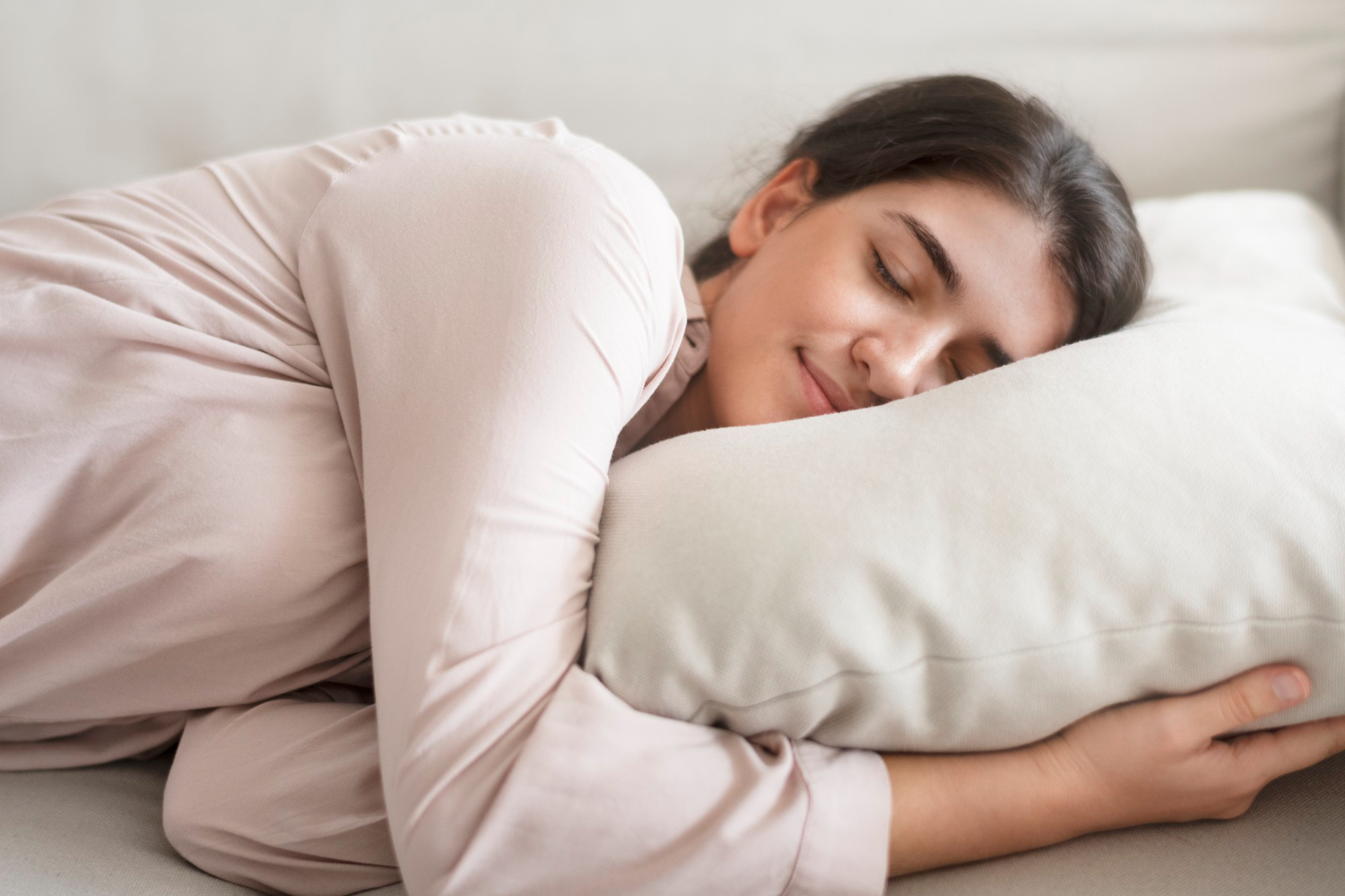 Jovem dorme tranquilamente com a cabeça no travesseiro