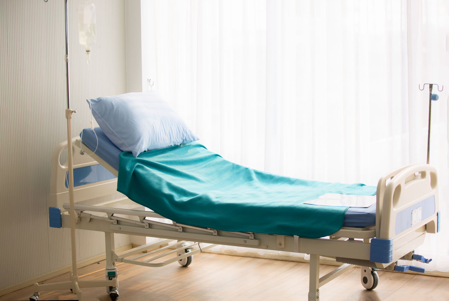 colchão hospitalar reclinado com travesseiro em um ambiente de hospital